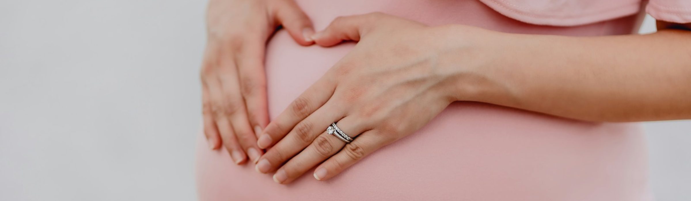 woman wearing gold ring and pink dress